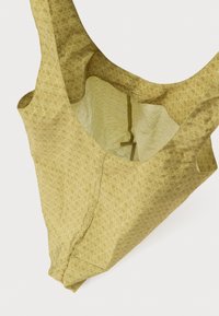 Svetlo rumena torbica z teksturiranim vzorcem, ki ima prostorno notranjost in okrogla ročaja. Izdelana iz gladkega, lahkega materiala.