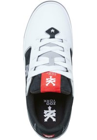 Hvide skate sneakers med sorte ruskindsdetaljer og grå overlejringer. Flade hvide snørebånd, rød mærkat med logo, polstret sort indre, mønstret sål.