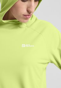 Limegrüner Pullover mit Kapuze, aus leichtem Stoff gefertigt. Verfügt über genähte Nähte und ein weißes Logo im Brustbereich.