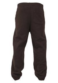 Pantaloni de trening de culoare maro închis, din bumbac, cu un brâu elastic, manșete conice și un singur buzunar pe spate. Textură netedă, design casual.