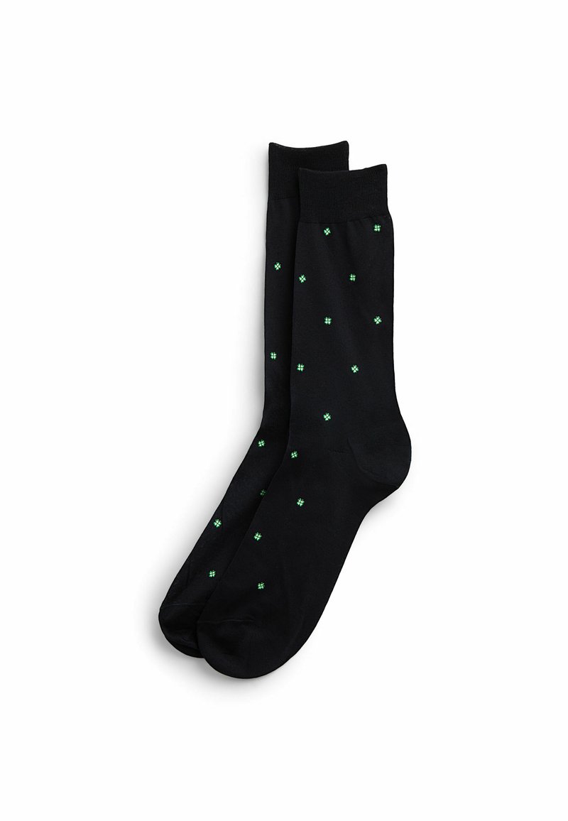 Sorte sokker med en glat tekstur, der har små grønne firkantede mønstre fordelt jævnt over overfladen.