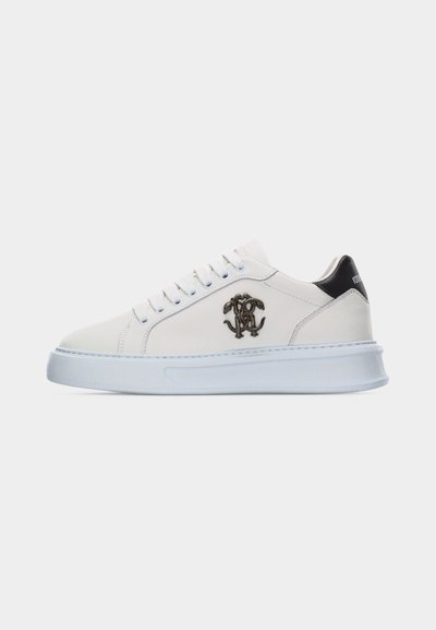Άσπρο sneaker χαμηλού τύπου με μαύρη ταμπέλα στη φτέρνα, άσπρα κορδόνια, παχύ σόλα και διακοσμητικό μονογράμμα λογότυπο στο πλάι.