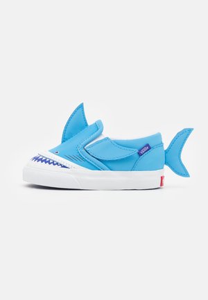 Baskets bleues pour enfants avec un motif de requin, avec une nageoire sur le dessus, une nageoire caudale au talon et un graphisme de bouche dentée sur l'avant.