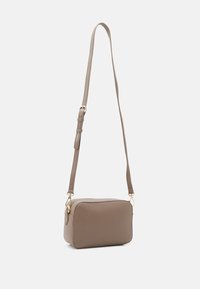 Hnědá obdélníková krosbody taška vyrobená z hladkého materiálu, s dlouhým nastavitelným popruhem a akcenty zlatého tónu.