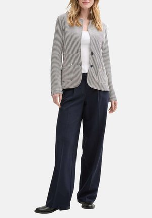 Streifensakko in marineblau und weißem Strickstoff mit geradem Schnitt, ausgestattet mit einem Knopfverschluss, zwei vorderen Taschen und kombiniert mit einer weit geschnittenen Hose.