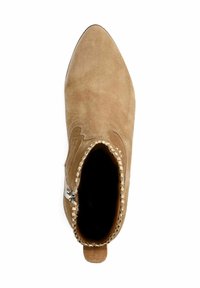 Tan suède enkellaars met een spits toelopende neus en decoratieve stiksels. Voorzien van een zijrits en een klein lipje aan de hiel.