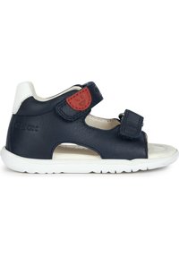 Sandalo in pelle blu navy con suola bianca, dotato di due cinturini in Velcro e un accento rosso. Design aperto con ritagli per la traspirabilità.