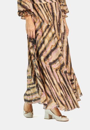 Vestido maxi con un patrón ondulado en rosa, marrón y dorado, con mangas largas y un diseño fluido, combinado con unos zapatos de tacón beige que tienen un lazo decorativo.