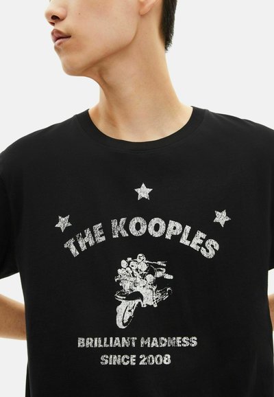 Juodas marškinėliai su tekstūriniu baltu motociklo grafiku, žvaigždėmis ir tekstu "THE KOOPLES BRILLIANT MADNESS SINCE 2008."