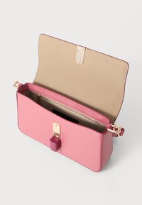 Sac à main en cuir rose avec un design structuré, doté d'un fermoir en or, d'une poche zippée intérieure et d'une texture lisse. Déclispé, montrant l'intérieur.