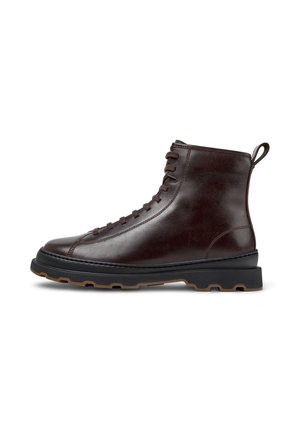 Bota de tobillo de cuero marrón con un acabado suave, punta redonda y cordones en la parte delantera. Presenta una suela de goma negra contrastante con un agarre texturizado.