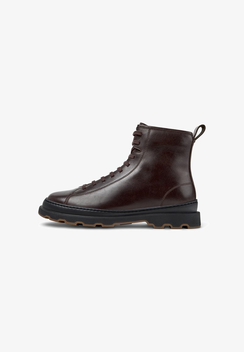 Brown leather ankle boot with a smooth finish, round toe, and lace-up front. Features a contrasting black rubber sole with a textured grip.