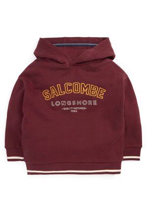 Bordeauxrode capuchontrui met de tekst "SALCOMBE LONGSHORE Quality Assured 1982", geribbelde manchetten en gestreepte zoom.