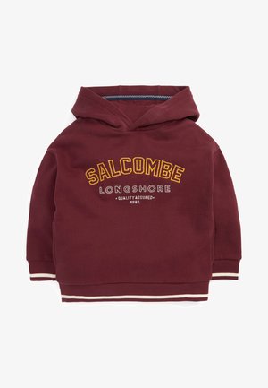 Sweat à capuche bordeaux avec le texte « SALCOMBE LONGSHORE Quality Assured 1982 », poignets côtelés et ourlet rayé.