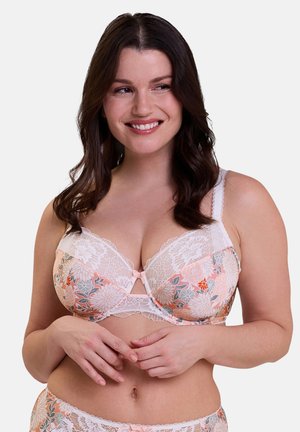 Soutien-gorge en dentelle florale dans un doux pêche avec des bords en dentelle blanche. Doté de motifs floraux et d'un nœud au centre. Les bretelles ajustables améliorent l'ajustement.