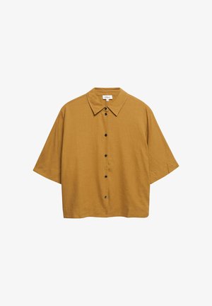 Camicia giallo senape a maniche corte con colletto, bottoni neri e vestibilità ampia e squadrata.