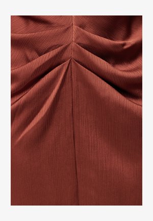 Roostevärvi kangas, millel on peen vertikaalne tekstuur ja kogutud, volditud detailid, mis loovad sümmeetrilise, kalasaba meenutava mustri.