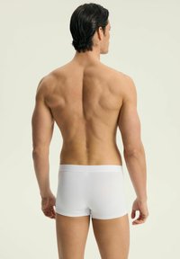 Białe bawełniane bokserki pokazane z tyłu, charakteryzujące się dopasowanym krojem i elastycznym pasem. Gładka, lekka tekstura o minimalistycznym designie.