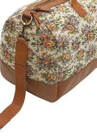 Sac en textile avec un motif floral dans des couleurs pastel, accents en cuir marron, forme rectangulaire et bandoulière en tissu amovible.