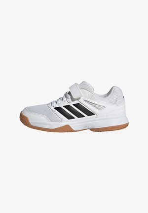Scarpa sportiva bianca con strisce nere, cinturino in velcro, tomaia in mesh e suola in gomma, vista di profilo laterale.