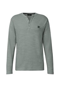 Pitkähihainen henley-paita vaaleanharmaasta teksturoidusta kankaasta. Varustettu napitettavalla kauluksella ja pienellä logopatchilla vasemmassa rinnassa.