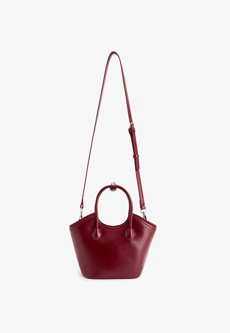 Borsa a mano rossa in pelle con una forma strutturata, doppie maniglie superiori e una tracolla staccabile. Texture liscia con decorazioni minime.