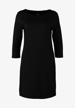 Czarna, dopasowana sukienka z okrągłym dekoltem i rękawami o długości trzech czwartych. W połączeniu z kremową kopertówką i czarnymi botkami na kostkę. Gładki materiał.