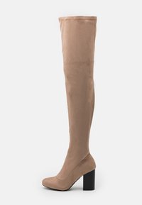 Beige Stiefel über dem Knie aus weichem Wildleder mit quadratischem Blockabsatz und nahtlosem Design. Die Textur ist glatt und matt, ohne Beschläge.