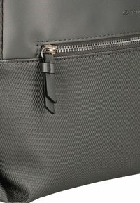 Grauer, strukturierter Rucksack mit glattem Oberteil und einer Reißverschlusstasche. Verfügt über einen Metallreißverschluss und ein elegantes Design. Hergestellt aus strapazierfähigem Material.