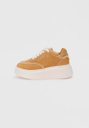 Tan suède sneaker met witte veters, imitatiebont afwerking, dikke witte plateauzool en "Karl Lagerfeld" logo aan de zijkant en hieltab.