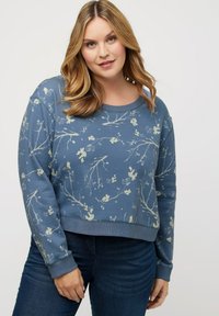 Sudadera azul con un estampado floral en tonos claros. Presenta un escote redondo y puños acanalados, diseño corto, tejido suave y texturizado.
