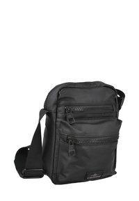 Bolso bandolera negro de nylon con dos bolsillos delanteros con cremallera, correa ajustable, textura suave y marca discreta en el frontal.