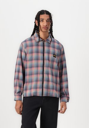Men's zip-up plaid jacket in blue and pink tones, featuring a collared neckline, long sleeves, and left chest logo patch. Woven fabric texture.