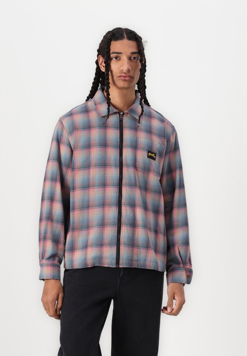 Men's zip-up plaid jacket in blue and pink tones, featuring a collared neckline, long sleeves, and left chest logo patch. Woven fabric texture.