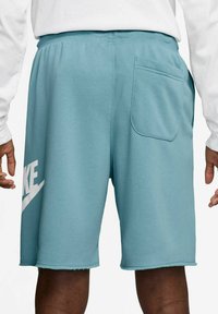 Pantaloni sportivi azzurri chiari realizzati in tessuto morbido, dotati di una fascia elastica in vita e di una tasca posteriore. Grande grafica del logo bianco sul lato.