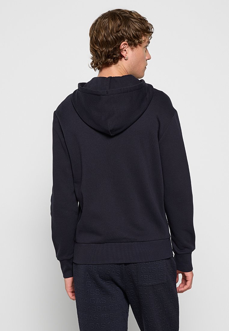 Granatowy sweatshirt z miękkiego materiału, z kapturem, ściągaczami przy mankietach i na dole, o gładkim wzorze odpowiedni do codziennego noszenia.