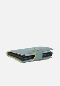 Light blue leather wallet with yellow accents, snap closure, and a slim design, holding a black card holder inside. Smooth texture.