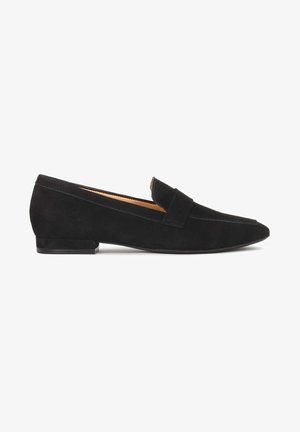 Mocassin plat en daim noir avec bout pointu, petit talon et détail de sangle sur le dessus, présenté de profil sur fond blanc.
