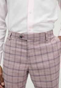 Braun und mauve karierte Hose mit Knopfverschluss, ausgestattet mit einem strukturierten Taillenbund und Taschen, aus leichtem Stoff gefertigt.