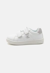 Des baskets blanches avec une finition en cuir lisse, dotées de deux bandes Velcro et d'un intérieur bleu clair. Accents argentés sur le talon.