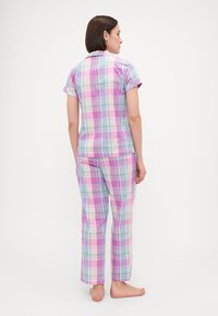 Πυτζάμα κοντομάνικη σε καρό σχέδιο σε παστέλ χρώματα, με αποχρώσεις λιλά, μέντας και ροζ, σε άνετη γραμμή και παντελόνια ίσιας γραμμής.