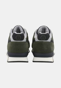 Baskets en daim vert foncé avec une languette grise rembourrée, des accents noirs et une semelle blanche. Présente un logo circulaire sur les talons.