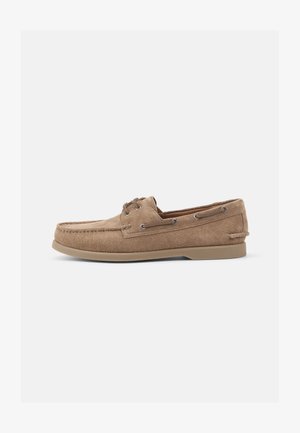 Σουέτ λόφερς σε καφέ χρώμα με σχέδιο μαλακής σόλας, διαθέτοντας μεταλλικές τρύπες και καουτσούκ σόλα. Χωρίς ορατά σχέδια ή λεπτομέρειες.