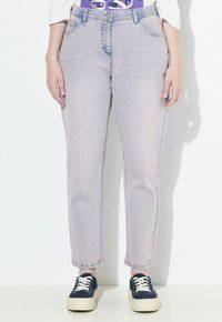 Jeans a vita alta di colore rosa chiaro con un taglio dritto, dotati di cinque tasche e una leggera sfumatura. Abbinati a sneaker blu navy.