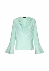 Blouse bleu clair à manches longues avec col drapé et manches évasées en cloche, affichée sur un fond blanc uni.