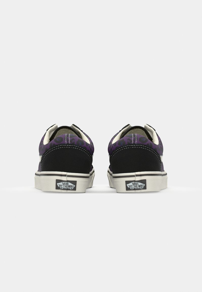 Des baskets noires et violettes avec une tige en tissu présentent un motif léopard, des coutures blanches contrastantes et une semelle en caoutchouc.