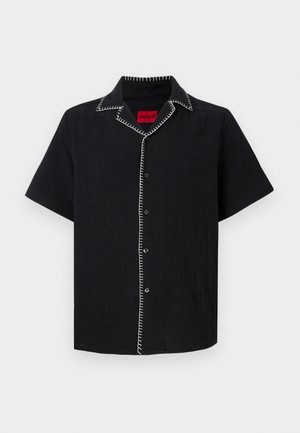 Chemise noire à manches courtes avec boutons, avec des détails de couture blanche le long du col et de la ligne de boutons, comportant une étiquette intérieure rouge avec "HUGO."