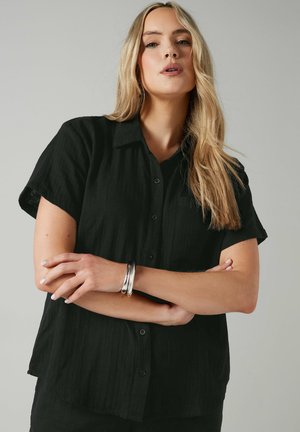 Black button-up shirt with a textured, lightweight fabric, short sleeves, and a collar. Features front buttons and a chest pocket.