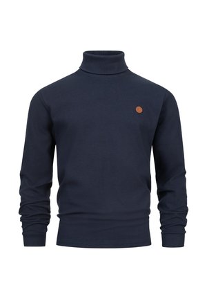 Pull en col roulé bleu marine en tissu côtelé, avec des manches longues et un petit logo en cuir rond à l'avant.
