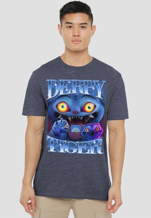 Young man wearing a navy blue T-shirt with large vibrant cartoon cat faces and the words "Derpy Tiger" in bold white letters.